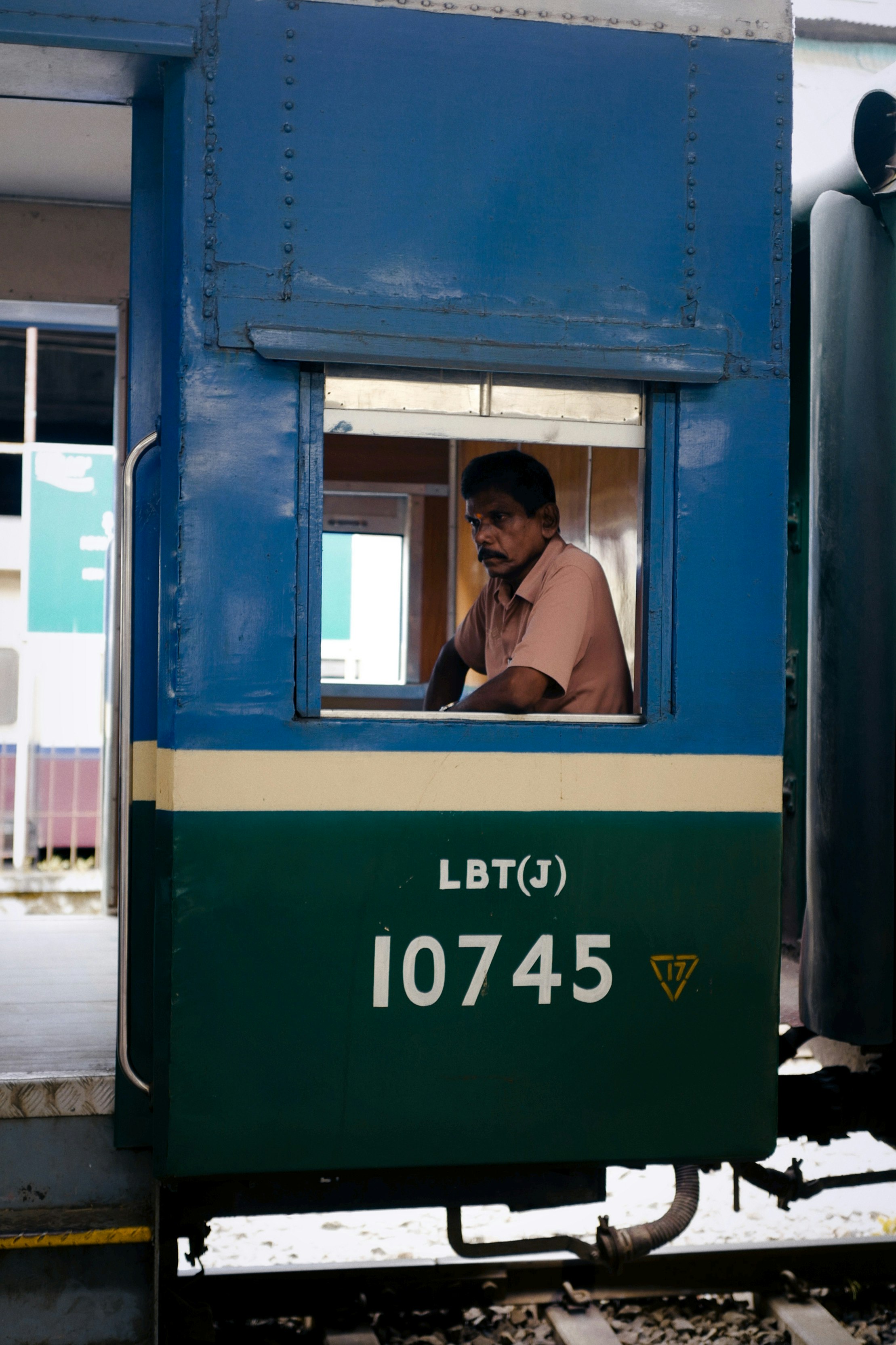 man in black jacket sitting on green train